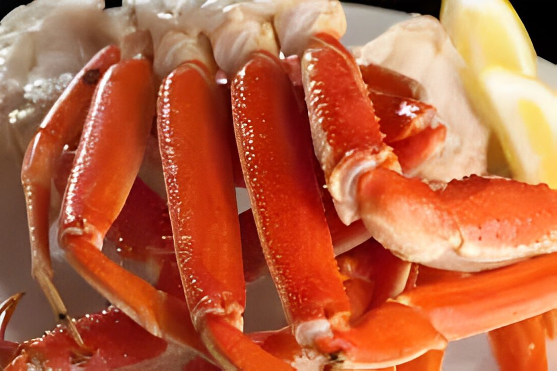 Cooked crab legs with lemon slices.