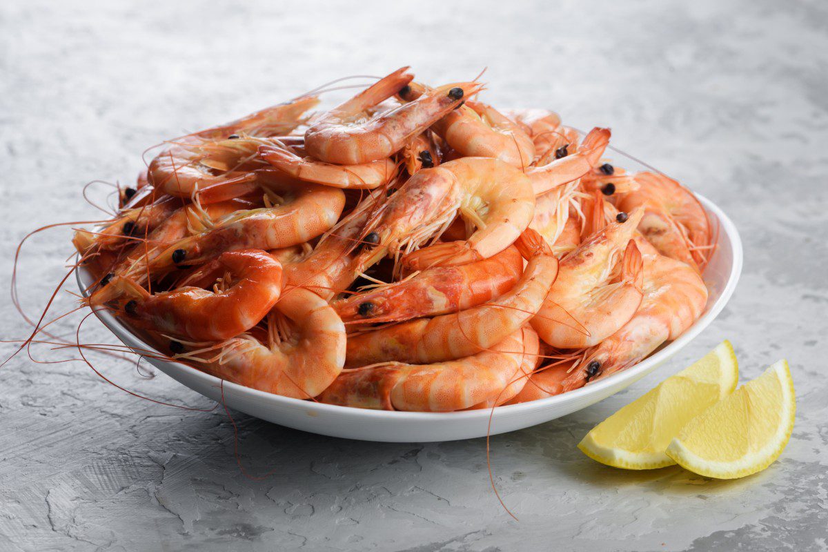 Plate of shrimp with lemon wedges.