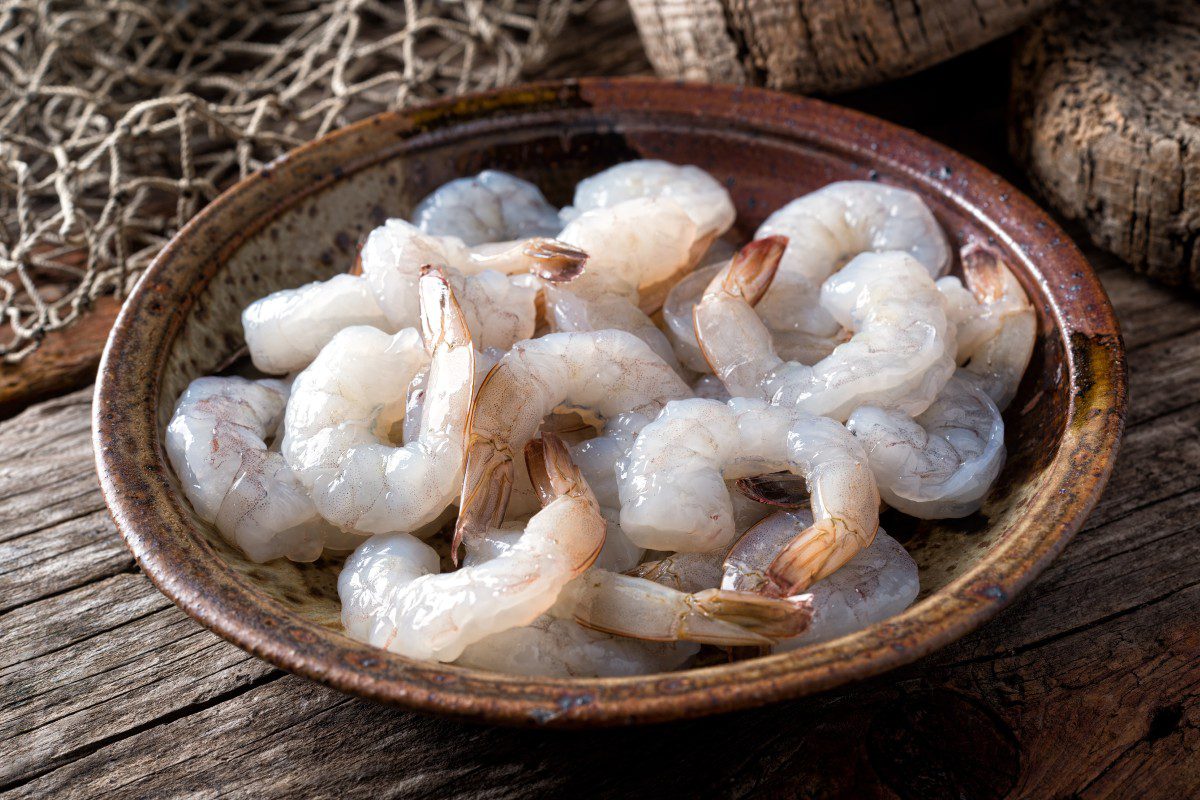 Raw shrimp in a rustic ceramic bowl.