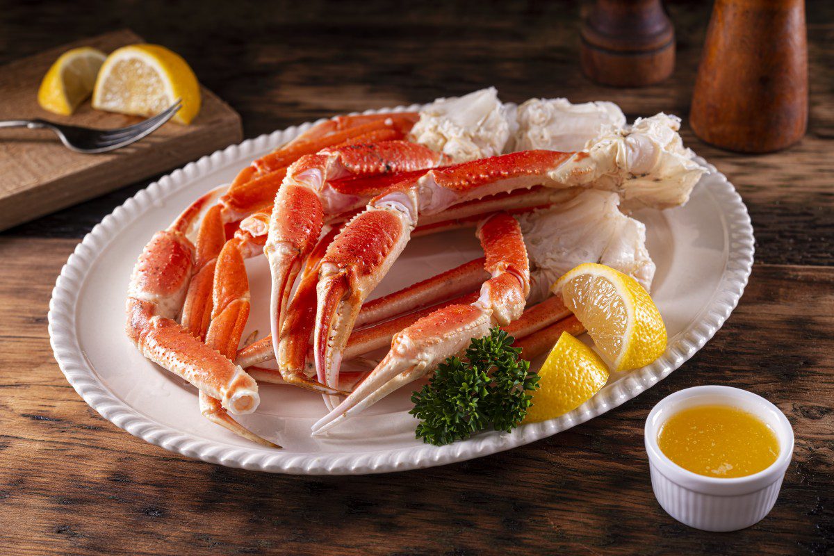 Plate of crab legs with lemon wedges.