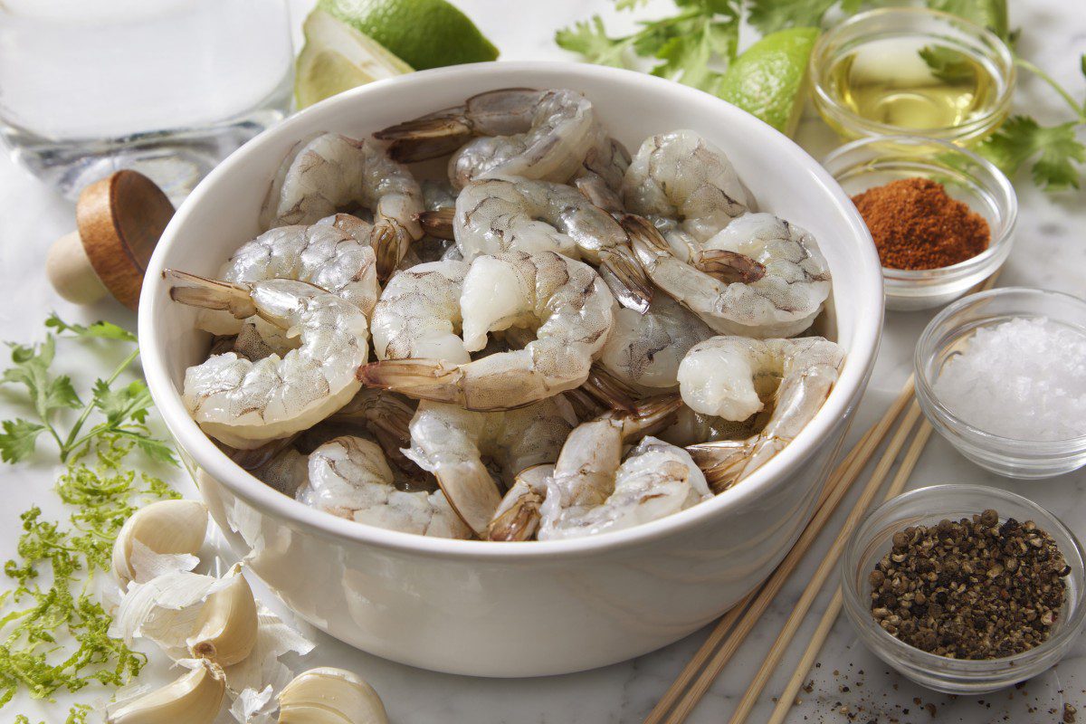 Bowl of raw shrimp with cooking ingredients.