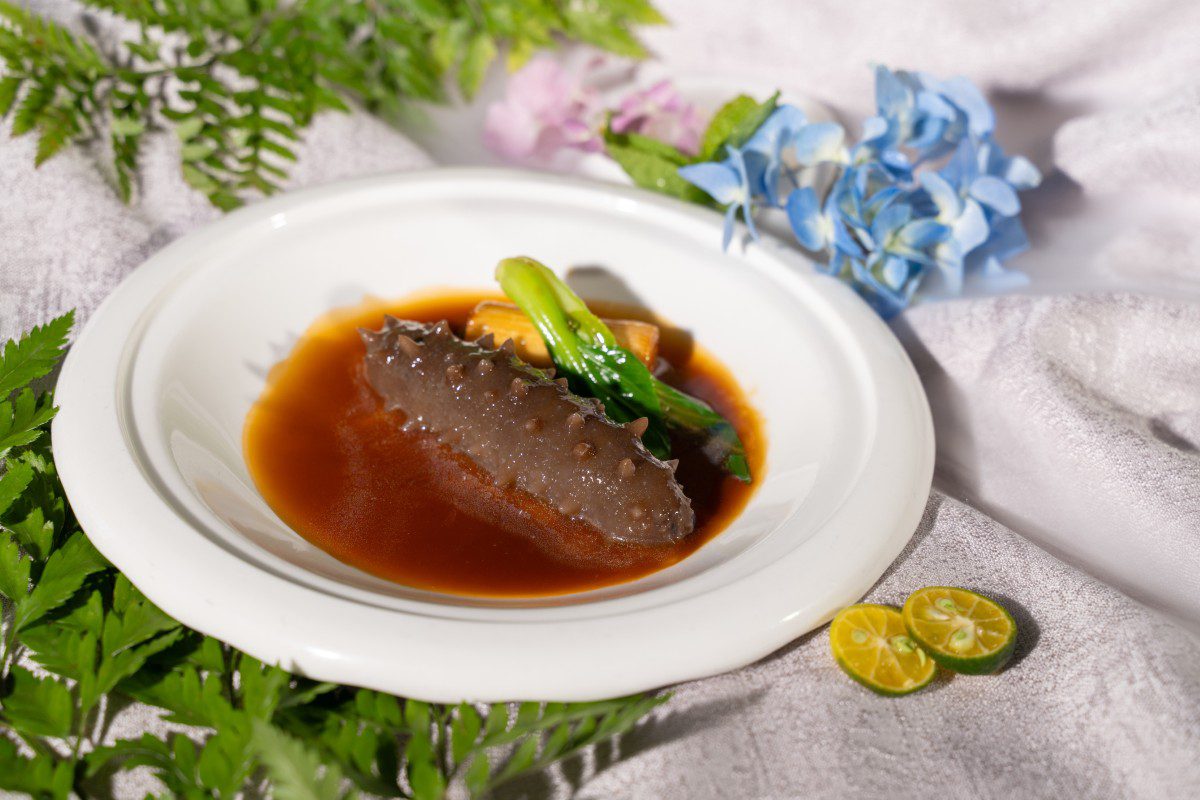 Sea cucumber dish with sauce and greens.