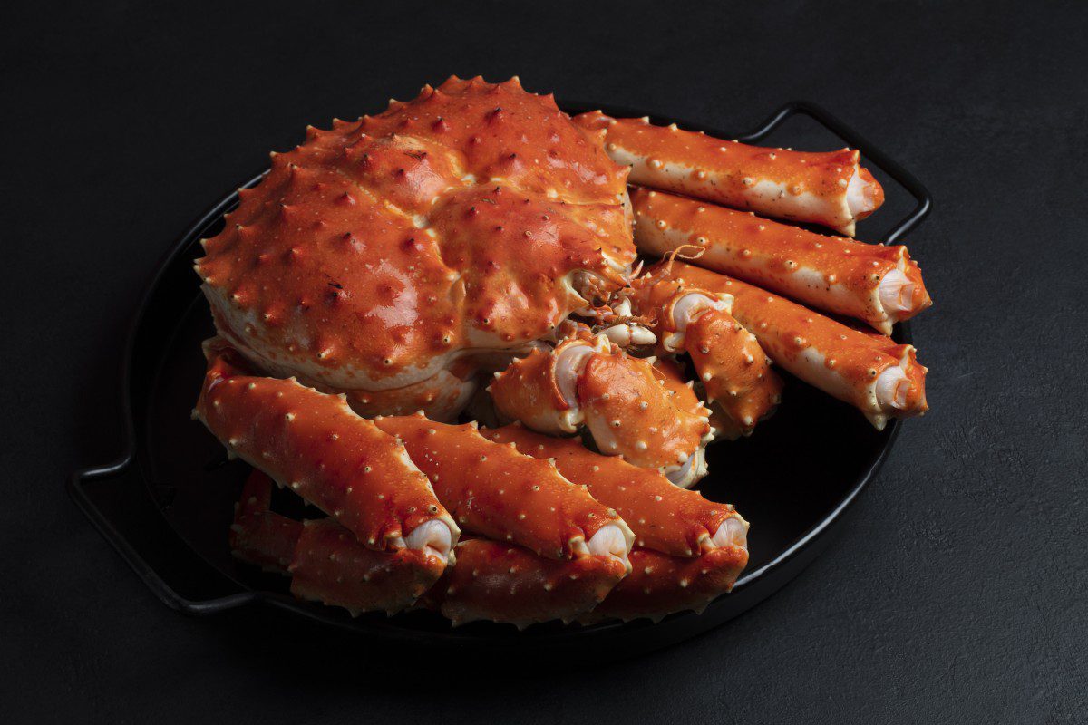 Cooked crab on a black serving plate.