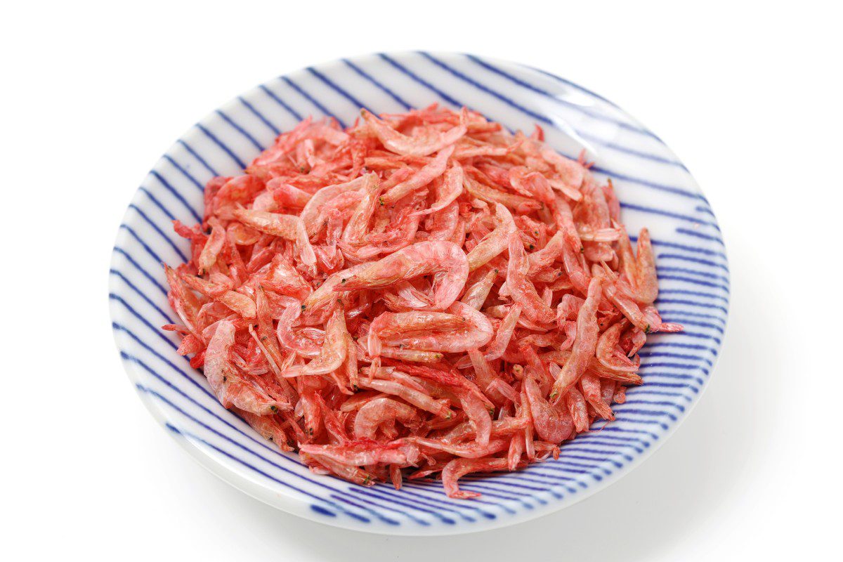 Dried shrimp in a blue striped bowl.