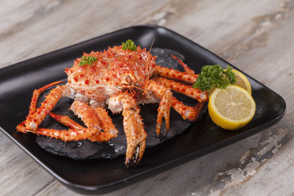Cooked crab with lemon and herbs garnish.