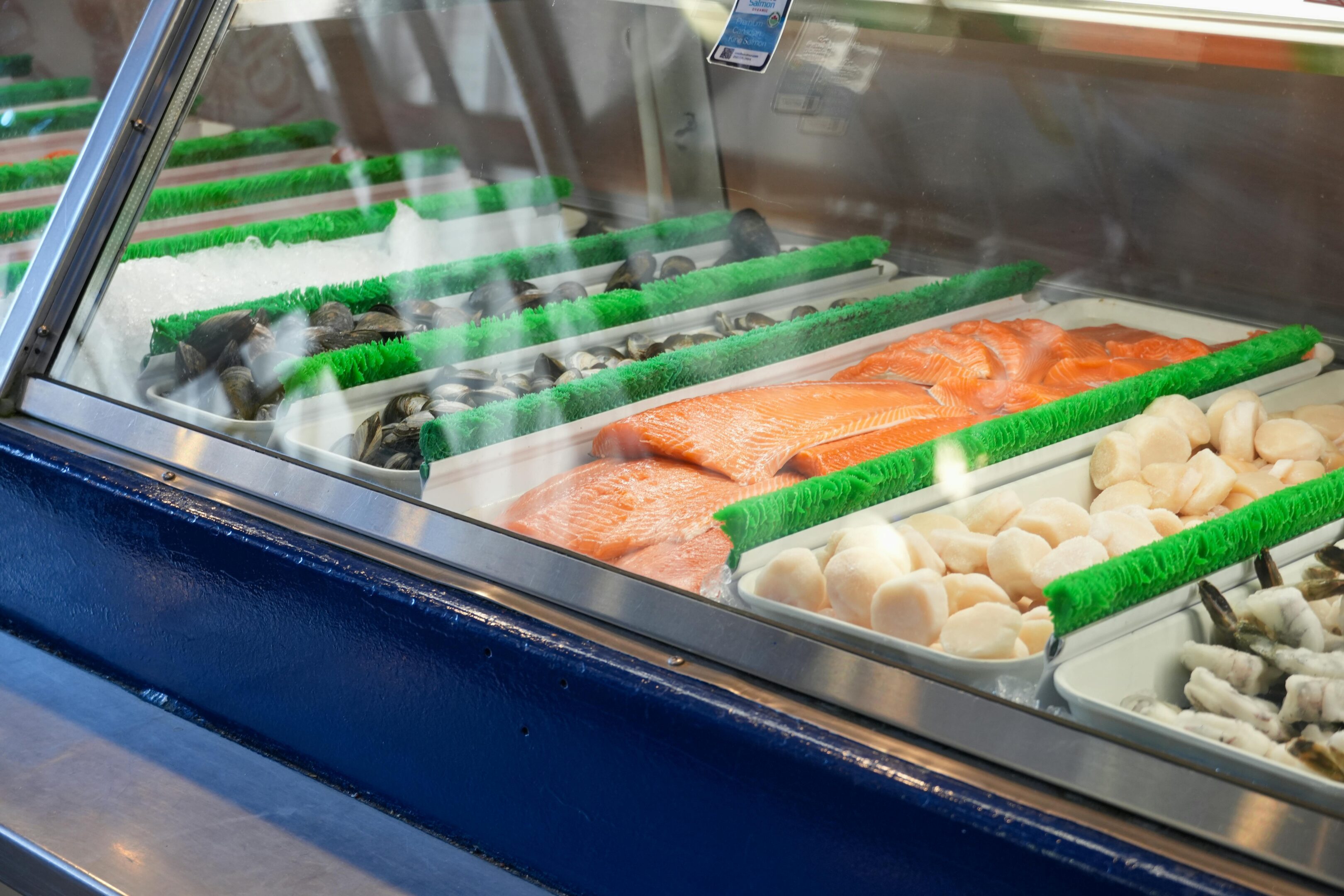 A display case with various fresh seafood and fish fillets.