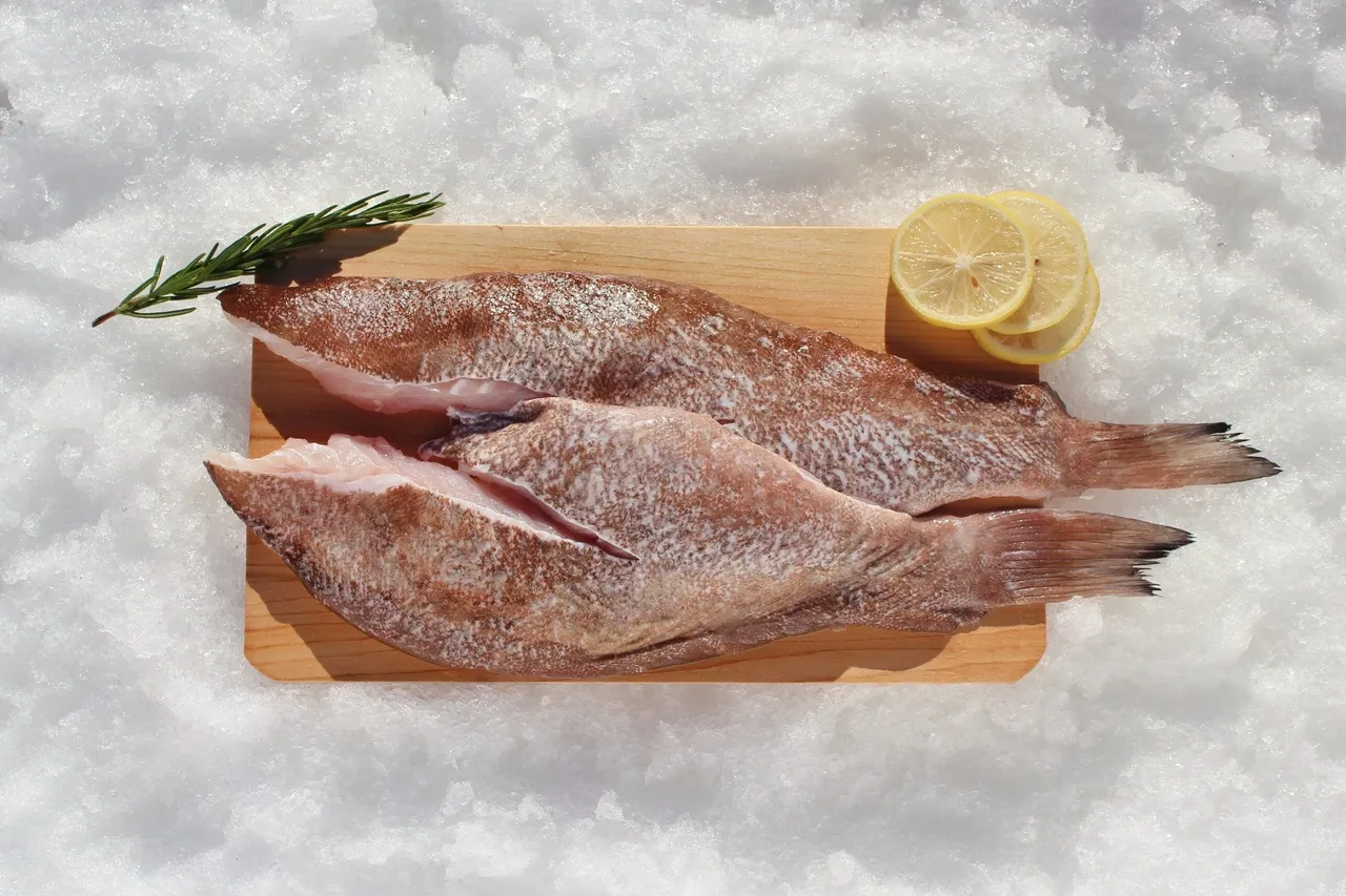Two fish on board with lemon slices.