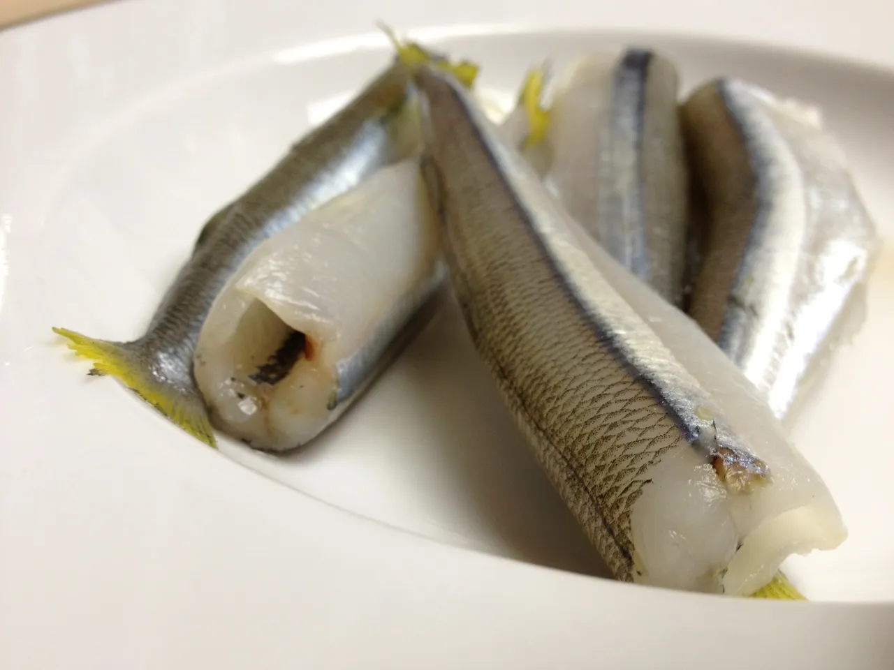 Raw fish on a white plate.